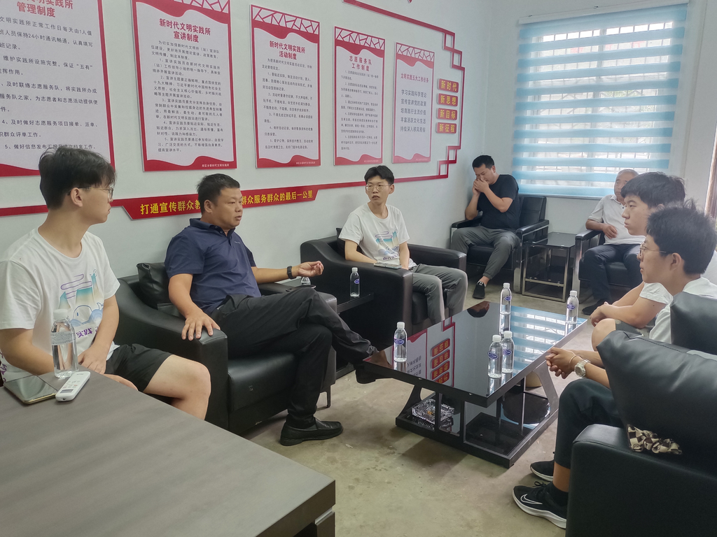 库区乡乡长王三国（左二）给团队成员介绍蓝莓产业的发展情况