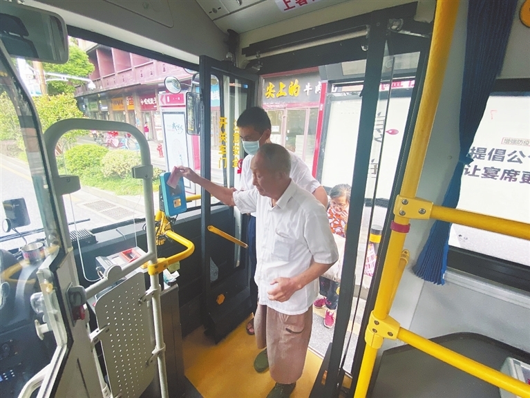 7路公交车司机在搀扶老人上车。 本报全媒体记者 蔡颖辉摄
