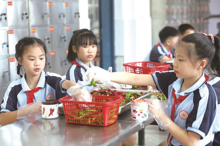 长沙县蓓蕾小学以劳动教育作为开学第一课，让每一位学生都能在学校里感受到劳动的付出与收获。图为学生正在学习制作剁辣椒。李杰 摄