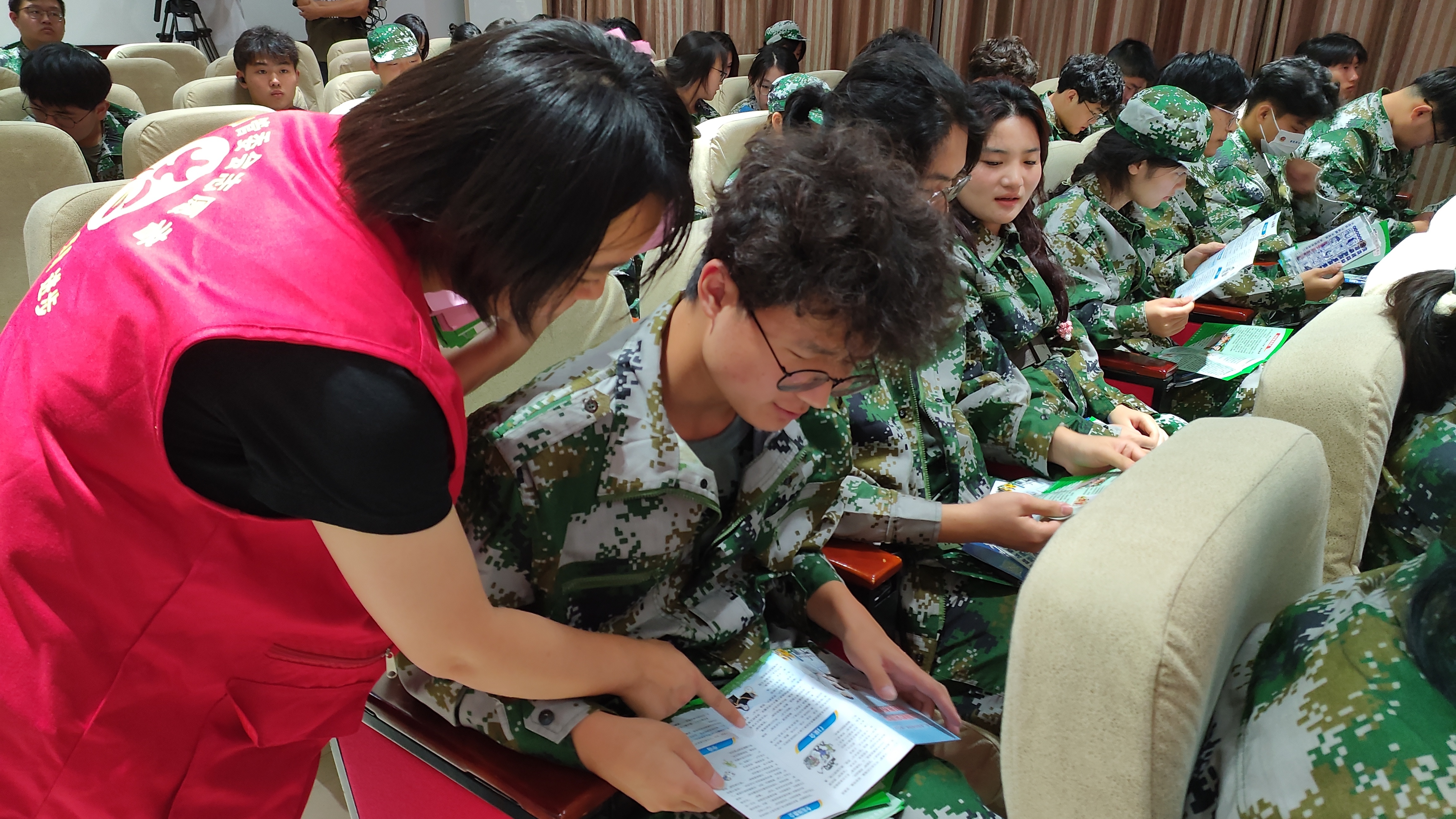 志愿者向学生发放宣传册。徐伟摄