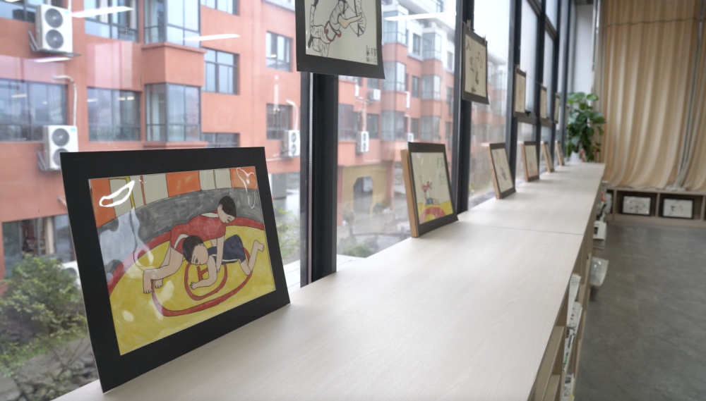 9月6日，麻田中心学校美术教室里，一幅孩子创作的摔跤简笔画