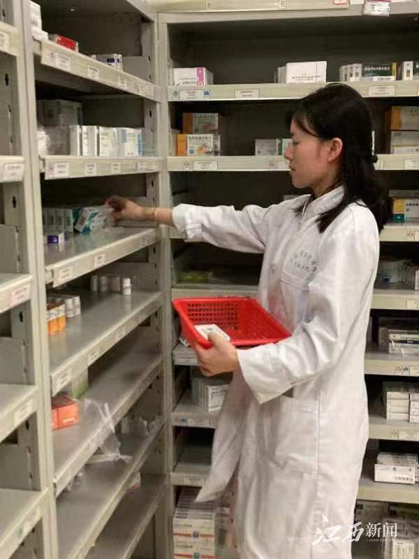 ▲吉安市一家定点医疗机构药房工作人员正在取药。摄影 | 江西日报全媒体记者洪怀峰