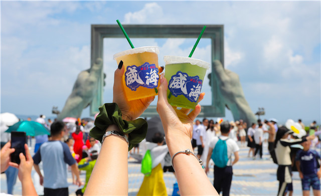 威海公园的威海之窗处，外地游客纷纷到此“打卡”。