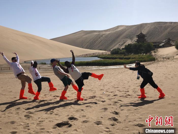 2023年9月，甘肃省国际交流员研习班学员参观敦煌鸣沙山月牙泉。甘肃省外办供图