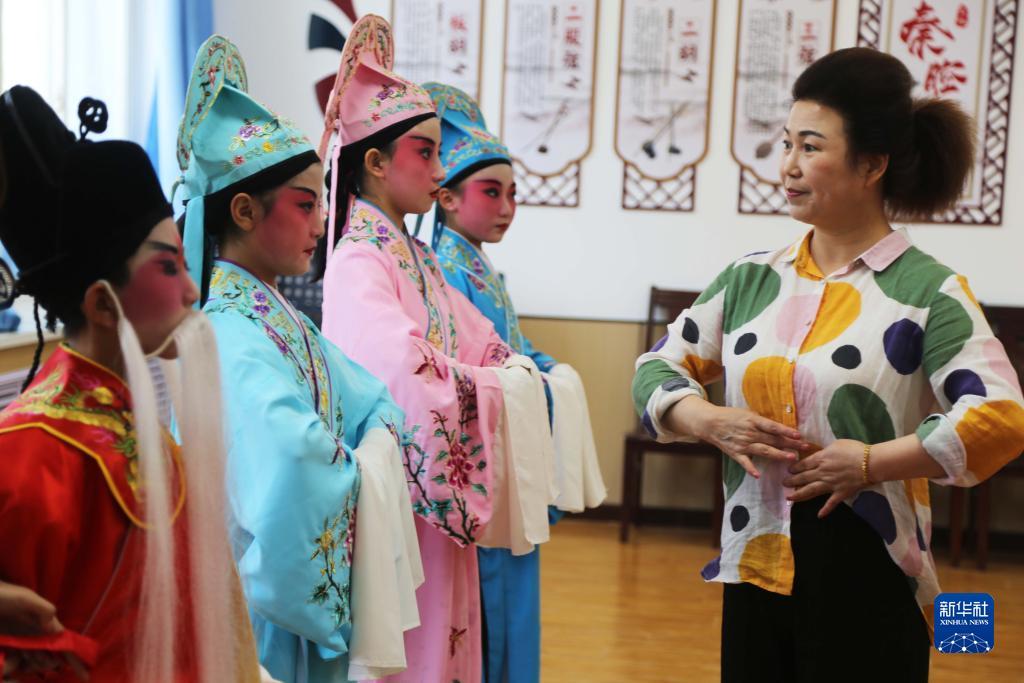 9月13日，在甘肃省定西市安定区福台小学，专业老师在辅导戏曲社团的学生们练习基本功。