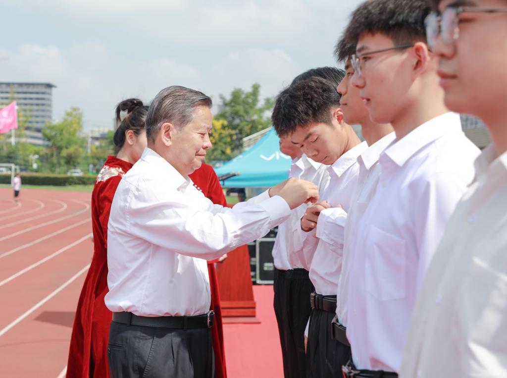 袁亮为新生代表佩戴校徽