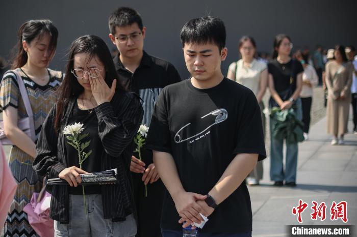 9月18日，在防空警报声中，侵华日军南京大屠杀遇难同胞纪念馆中的参观者驻足默哀。　泱波 摄