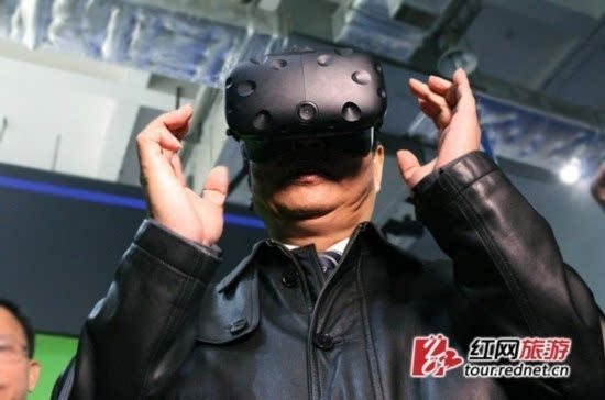（2016年旅博会上，时任副省长何报翔试戴VR眼镜，体验VR旅游）