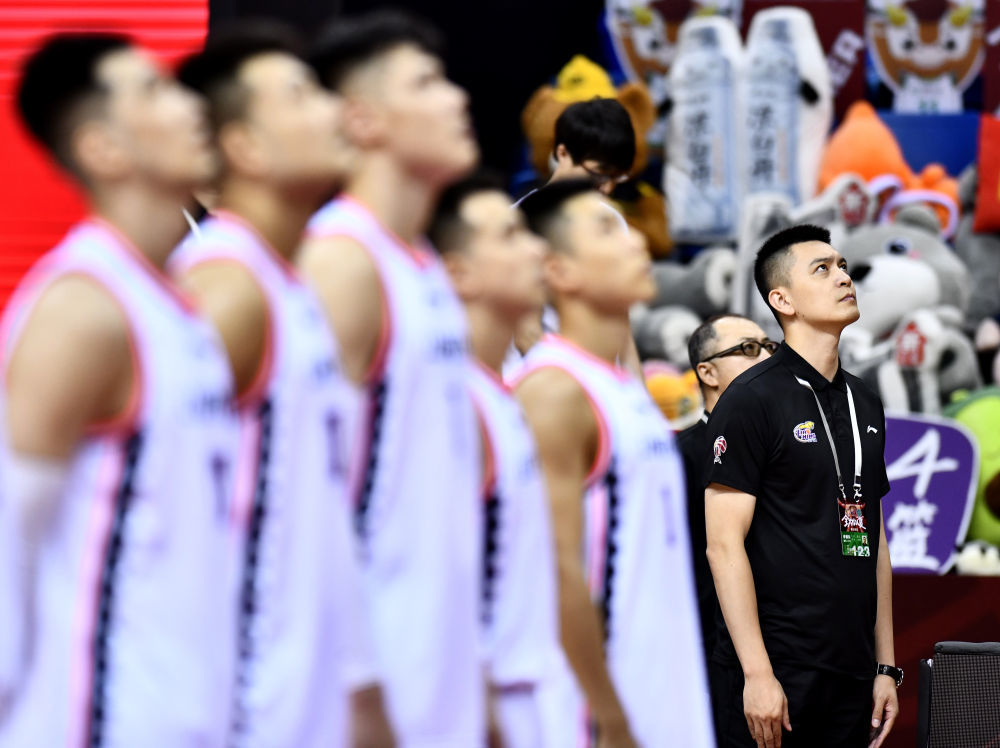 2019-2020赛季中国男子篮球职业联赛(CBA)复赛第二阶段(崂山赛区)比赛期间,杨鸣(右)与辽宁队队员在赛前升旗仪式上。新华社记者 郭绪雷 摄