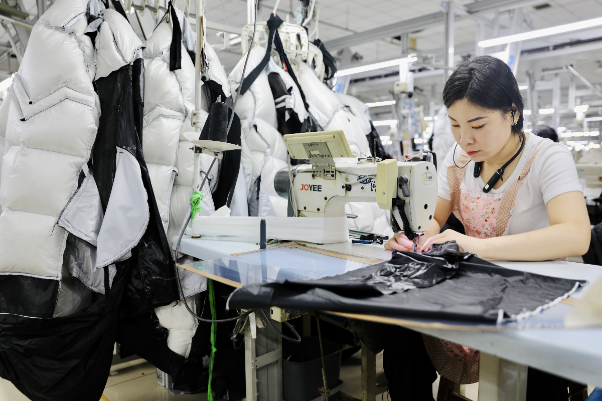在一家服装生产企业的生产车间,工人正在加工服装(赵一婕 摄)