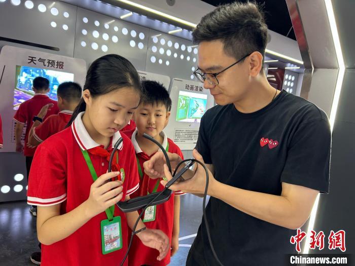 图为在江西九江市修水县何市镇中心小学AI科技馆，技术老师在“未来历史课”上教学生使用设备。　黄淼林 摄