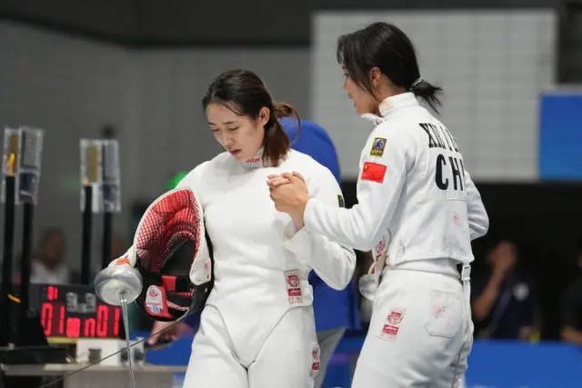 9月20日，钟秀婷（左）与谢林芝在杭州亚运会现代五项女子个人击剑大循环比赛中互相鼓励 薛宇舸 摄