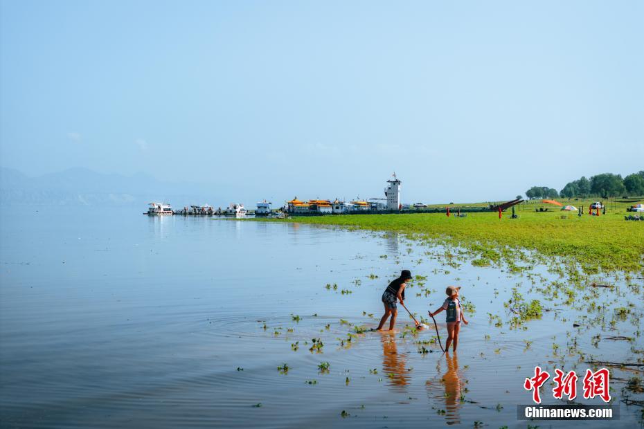 在莲花古渡景区内,孩子在水中捕鱼。邱活 摄
