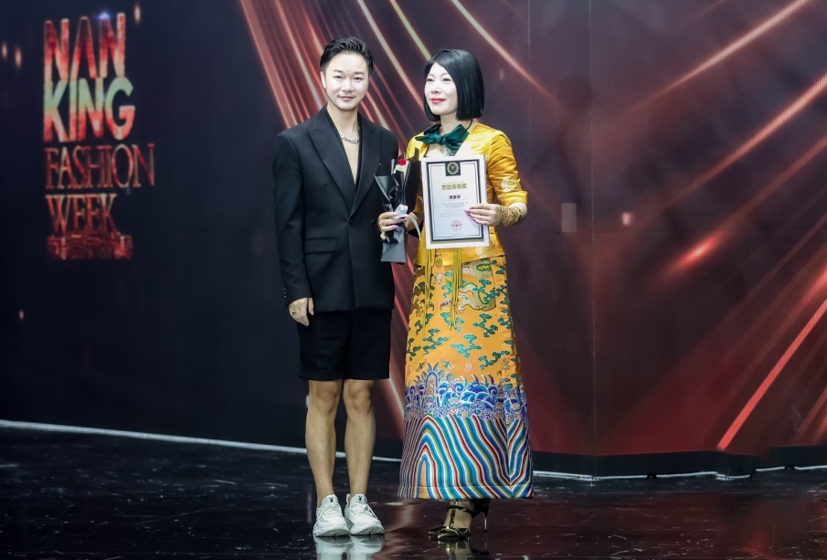 南京国际时尚周组委会副主席兼秘书长邹子涵（左）颁奖。