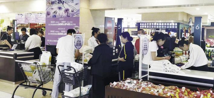 消费者在超市排队购买“十一”期间的生活必需品。 李依南 摄