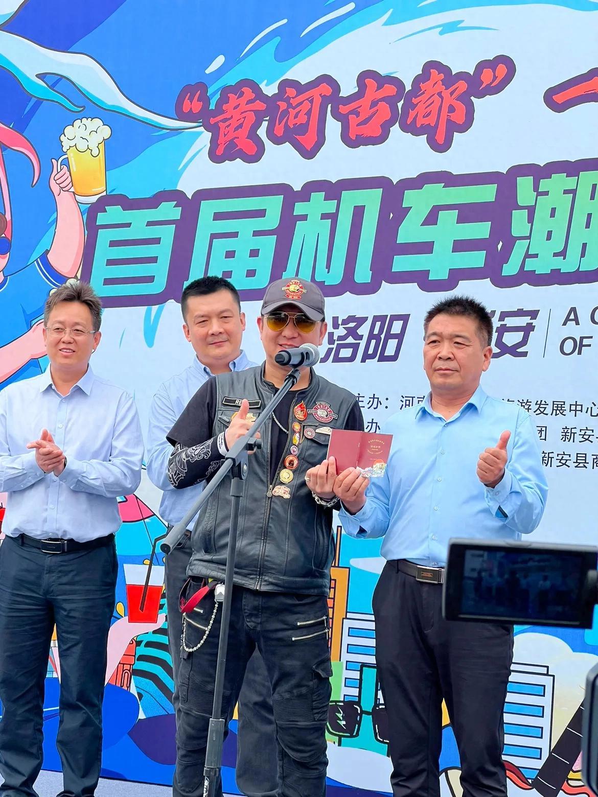 河南省文化和旅游发展中心主任陈占元向摩托车骑友颁发“黄河古都”一号旅游公路自驾游护照