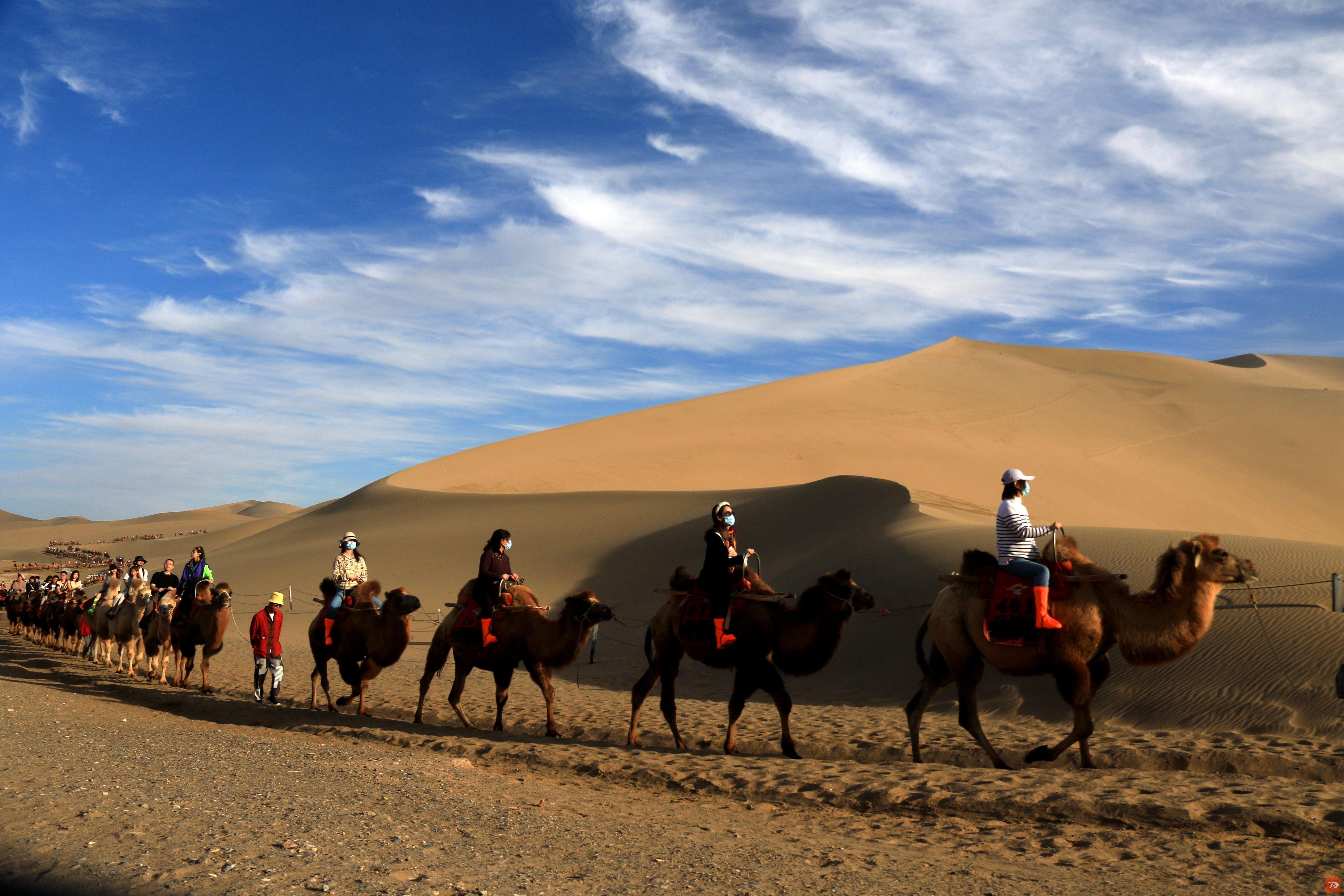 2023年9月29日，游客在甘肃省敦煌市鸣沙山月牙泉景区游览。