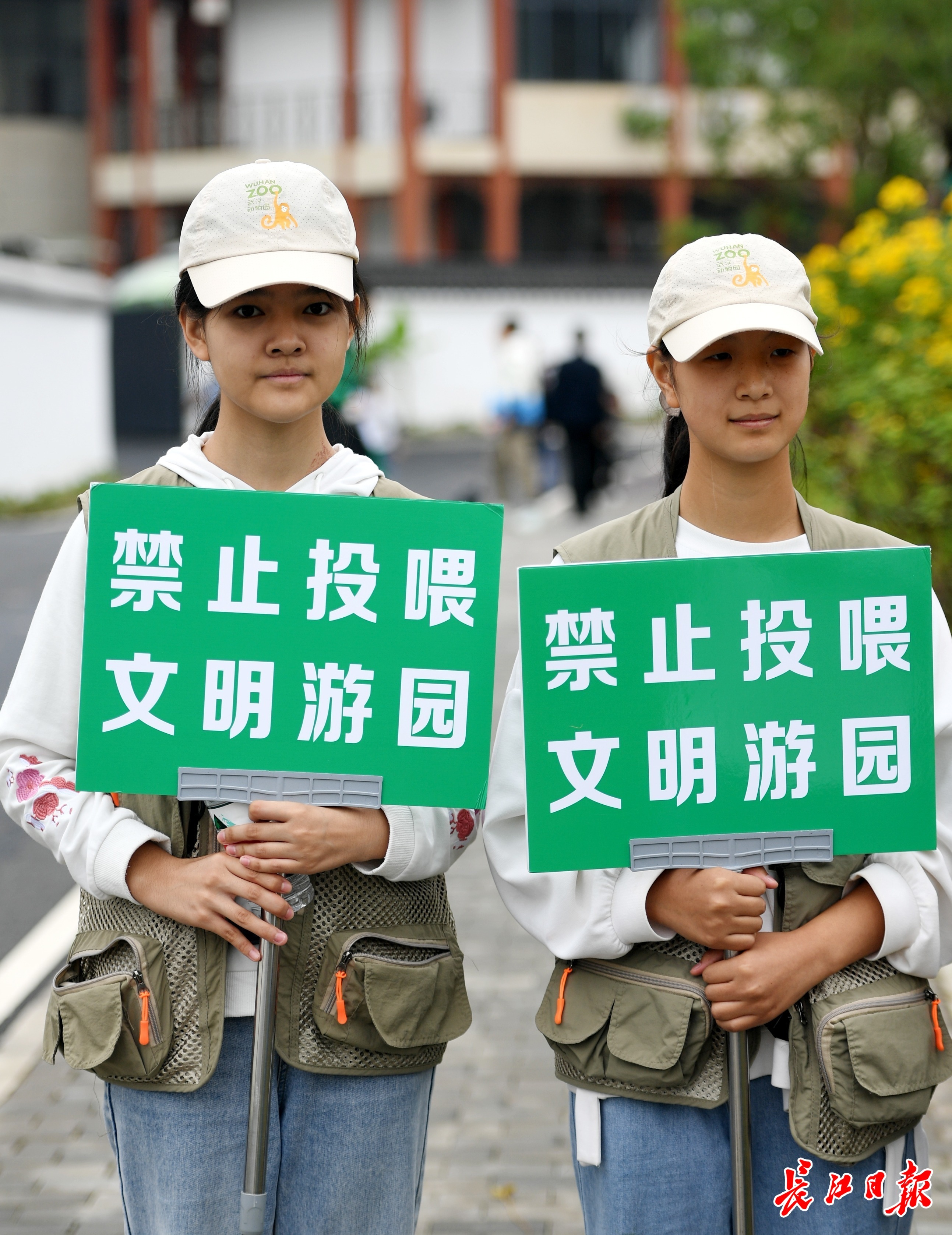 志愿者举牌提醒游客勿投喂动物。记者李子云 摄