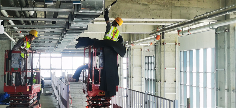 10月1日上午,雄安新区大学园图书馆项目施工现场,工人们正在馆内安装通风管道保温棉。 刘光昱摄