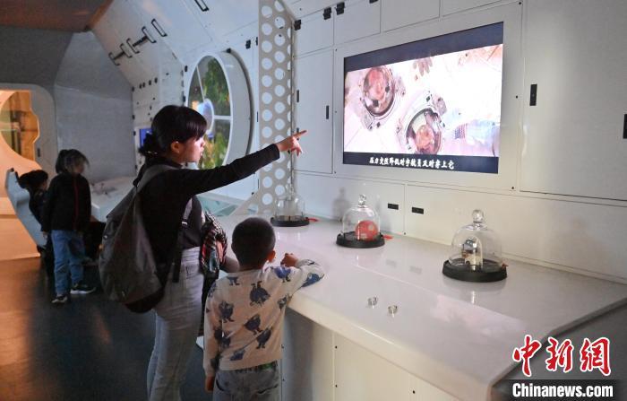 小朋友和家长在太空模拟舱参观。张瑶 摄