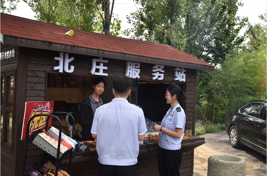 图为平山县税务局青年干部为北庄村民讲解优惠政策(张健 摄)