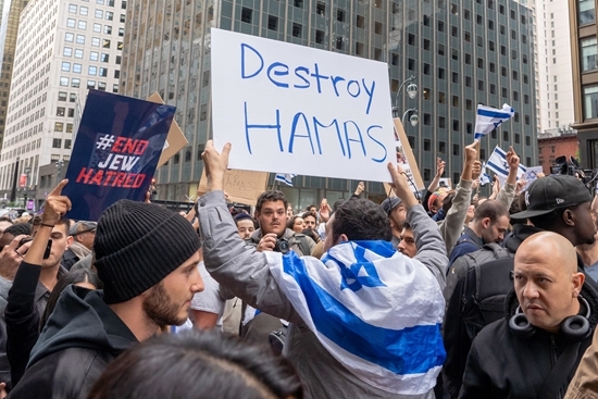 10月8日，美国多地举行支持巴以的大规模集会，巴以双方支持者在街头对立上演“混战”，图为一名亲以色列人士在纽约一场集会上高举“摧毁哈马斯”的标牌。视觉中国供图