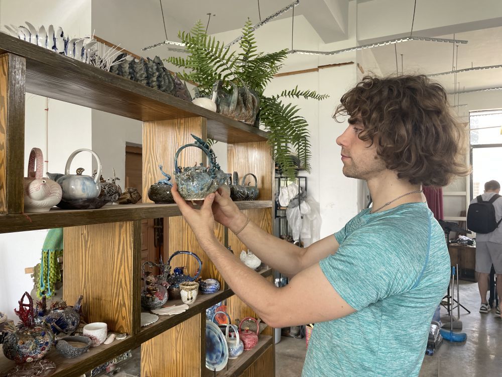 ↑ 在江西景德镇，美国青年丹尼斯在工作室内整理陶瓷作品（2023年5月30日摄）。