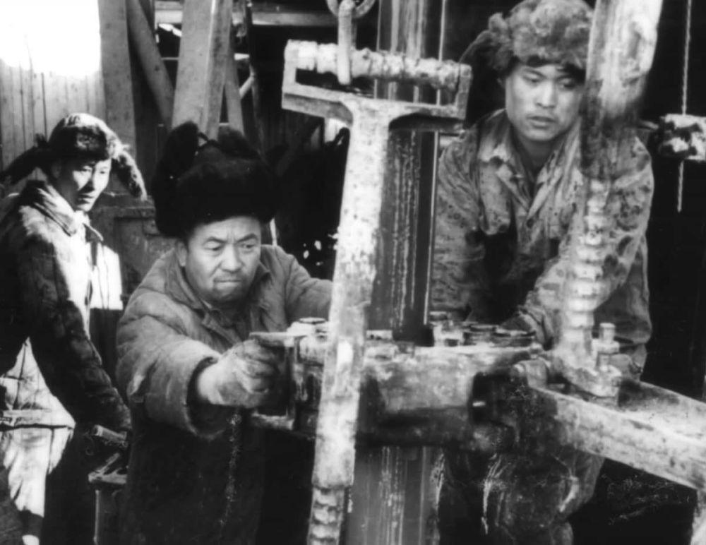 1959年，王进喜（中）和工人们在井架上（资料照片）。新华社发