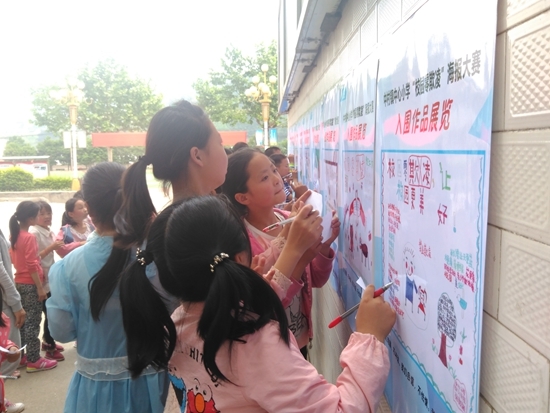 陕西妇源汇在某乡村小学举办“校园零欺凌”海报大赛，孩子们在作画、看海报。