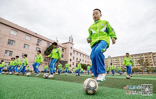 在广昌县第三小学操场上，校园足球队的队员们在进行盘带和控球训练。江西日报全媒体记者徐铮摄