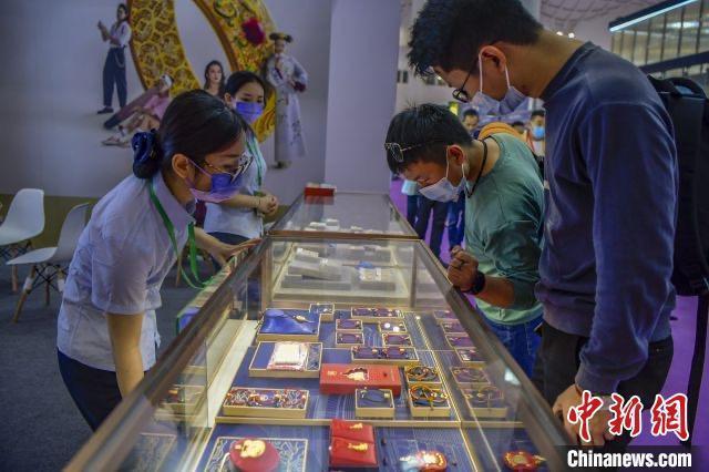 资料图:民众在2022世界珠宝发展大会的菜百展台上选购古法金饰品。 骆云飞摄