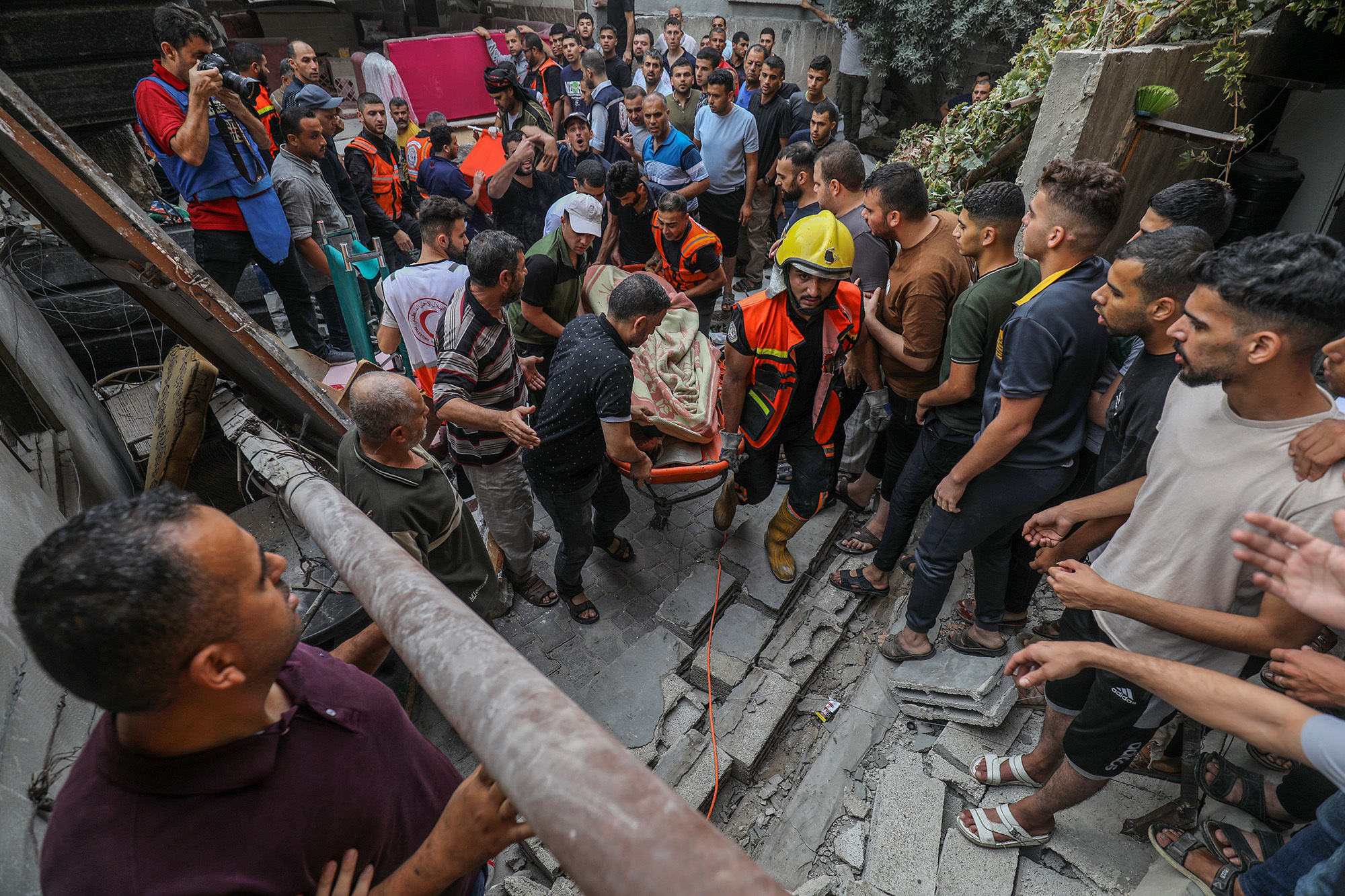 10 月 9 日，以色列对加沙拉法发动空袭，救援人员从倒塌的建筑物中救出遇难者的尸体。