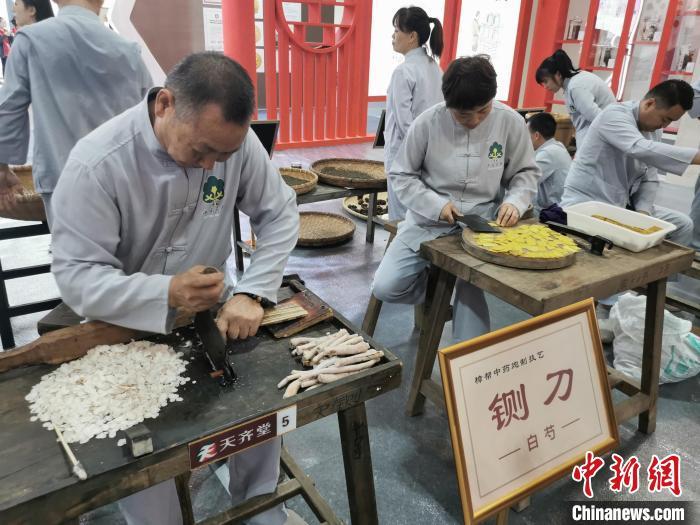 铡刀起落，一片片薄如纸的中药切片落在筛盘里。熊锦阳 摄