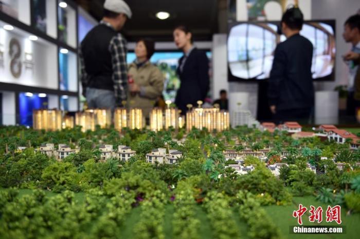 资料图：售楼人员向顾客介绍楼盘。