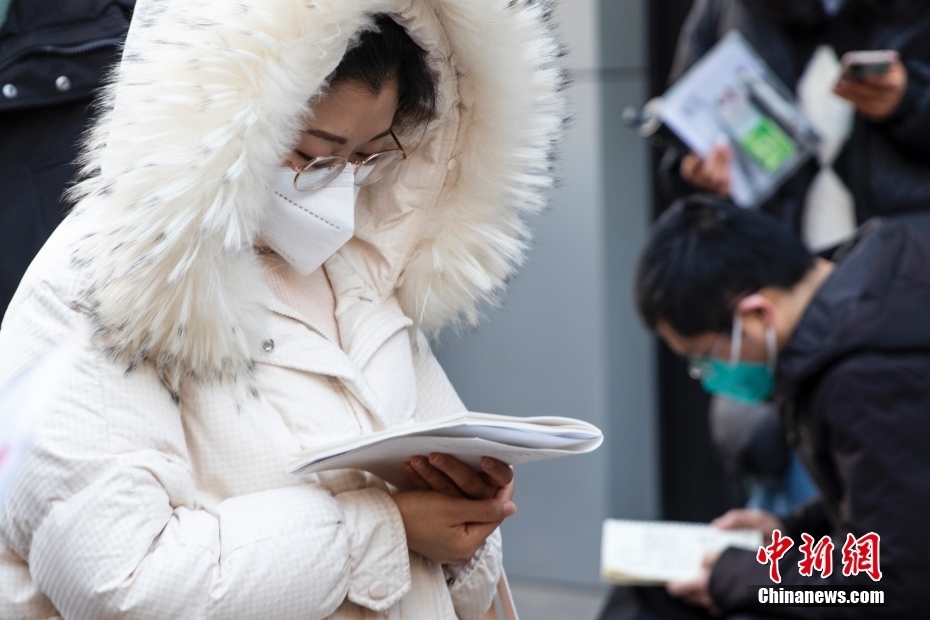 1月8日，郑州，河南省商务中等职业学校考点外，考生入场前复习。当日，中央机关及其直属机构2023年度考试录用公务员公共科目笔试举行。<a target='_blank' href='/'>中新社</a>发 程航 摄