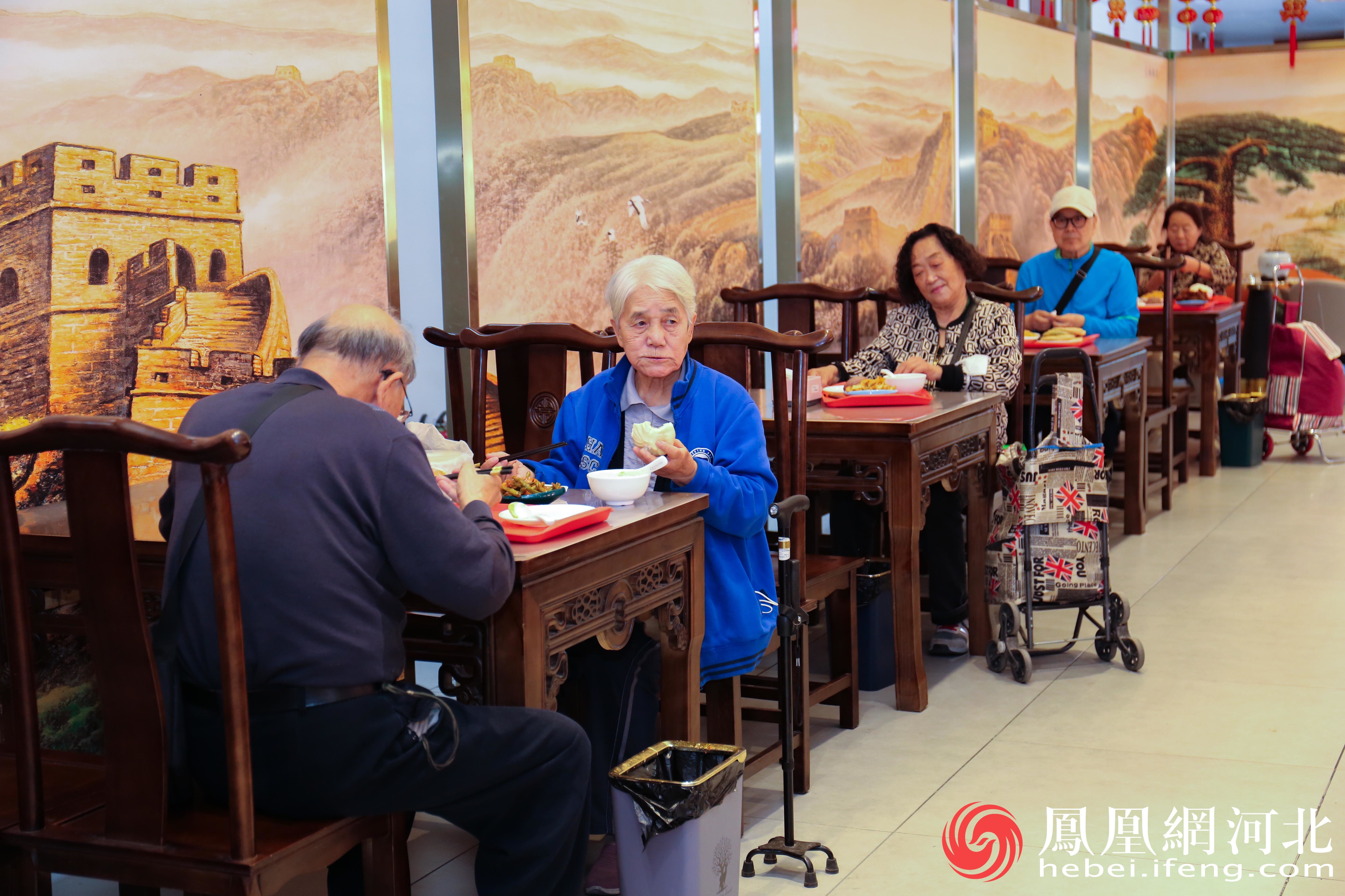“幸福大食堂”内老人们三三两两坐在一起就餐