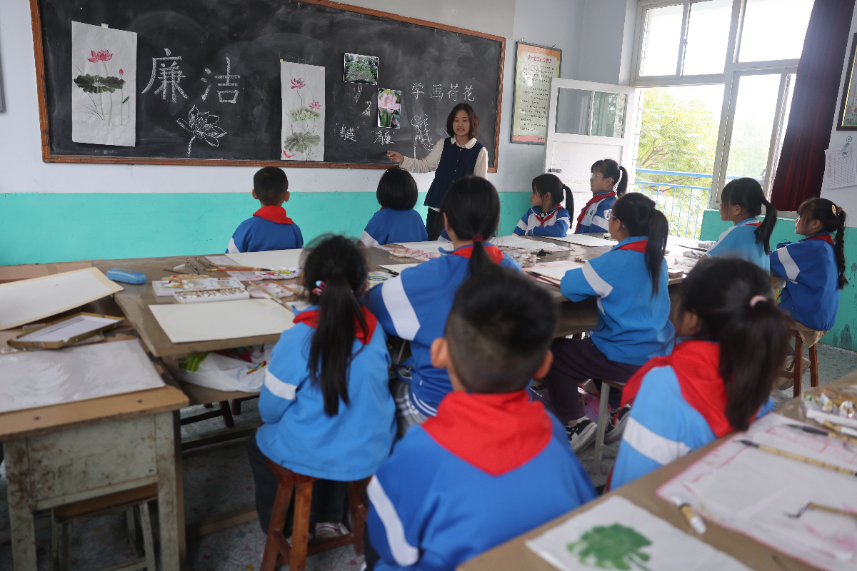 图为河北省宁晋县徐家河乡北四村联合小学，老师正在讲解绘画青莲的技巧。 张新慧 摄