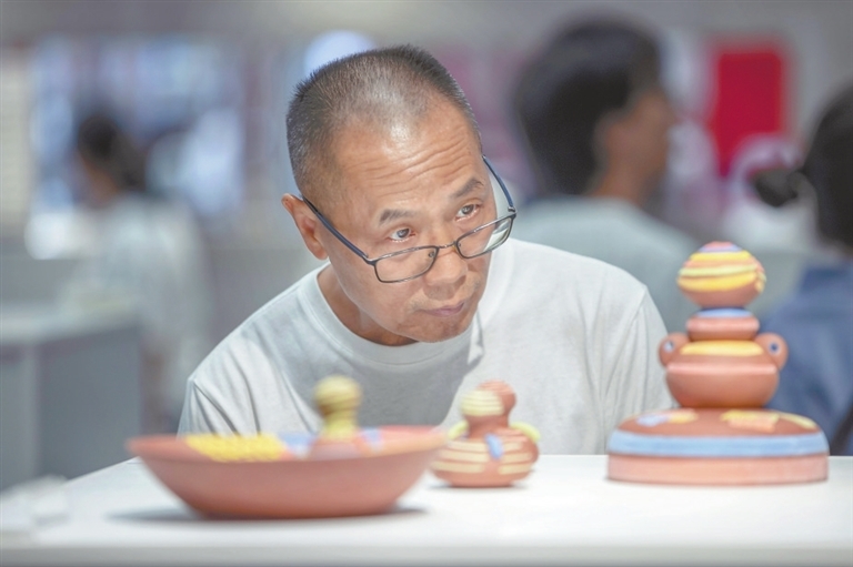 10月18日，在景德镇陶博城会展中心，市民正定睛观赏陶瓷艺术作品。