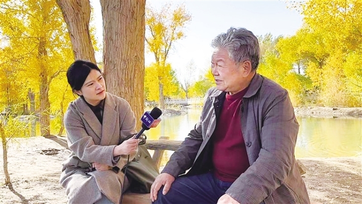 10月16日,潮湖林场原副场长王端政在金塔沙漠胡杨林景区接受中新社记者采访。