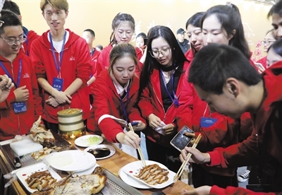 首届北京国际非遗周，志愿者们在品尝国家级非遗美食全聚德烤鸭。新京报记者 浦峰 摄