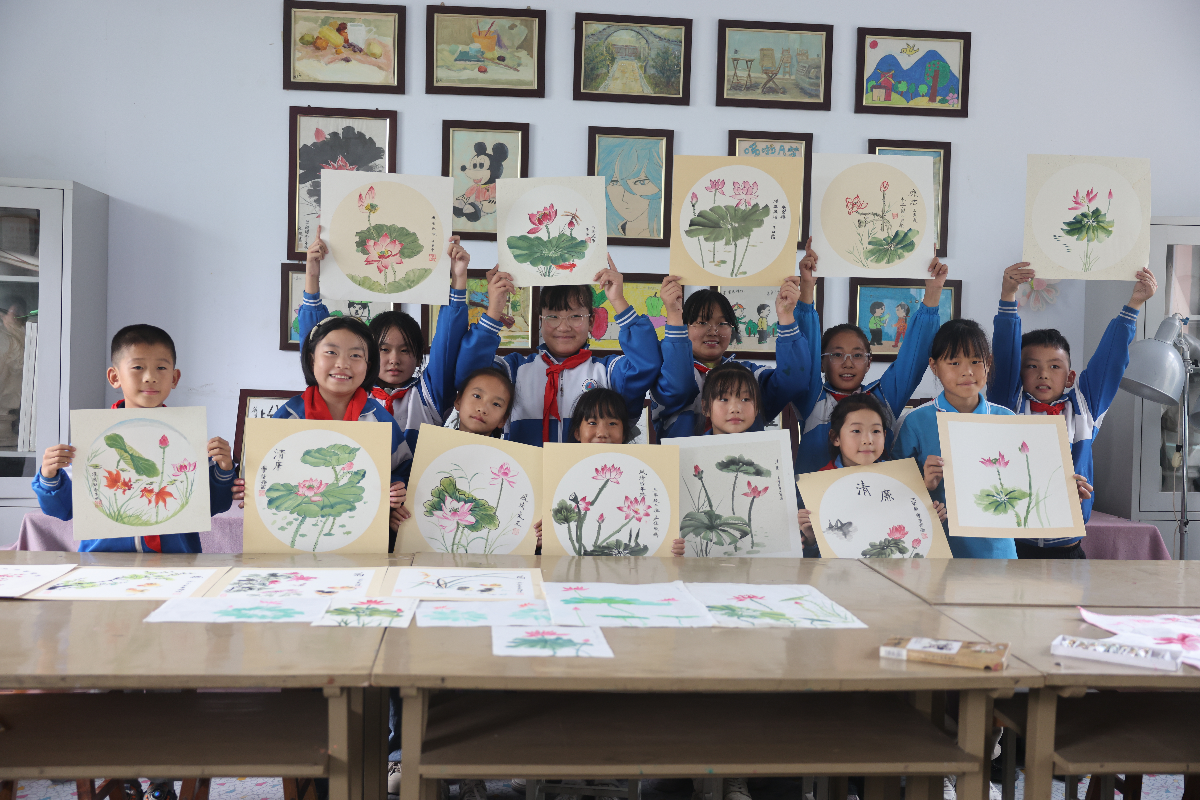 图为河北省宁晋县徐家河乡北四村联合小学，学生们正在展示刚画好的青莲。 张新慧 摄