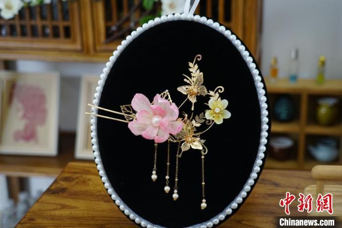 山东“90后”小伙王平展示其用大蒜皮制成的精美头饰。王采怡 摄