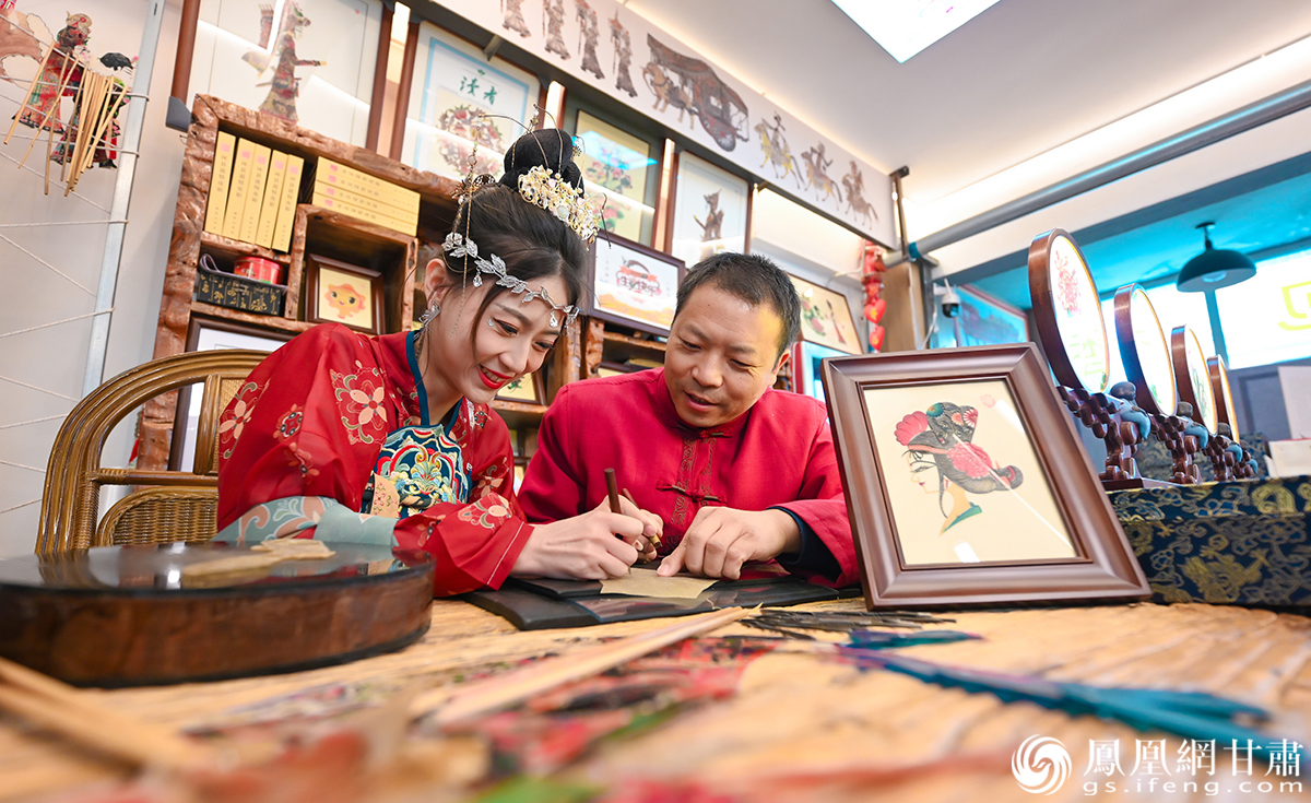 在甘肃省庆阳市环县环州故城，凤凰小编向环县道情皮影戏市级代表性传承人张治文（右）学习皮影制作技艺。杨艺锴　摄