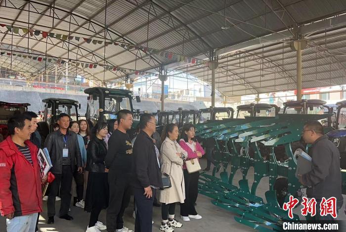 图为培训班学员通过基地现场教学学习农机知识 冯文强 摄