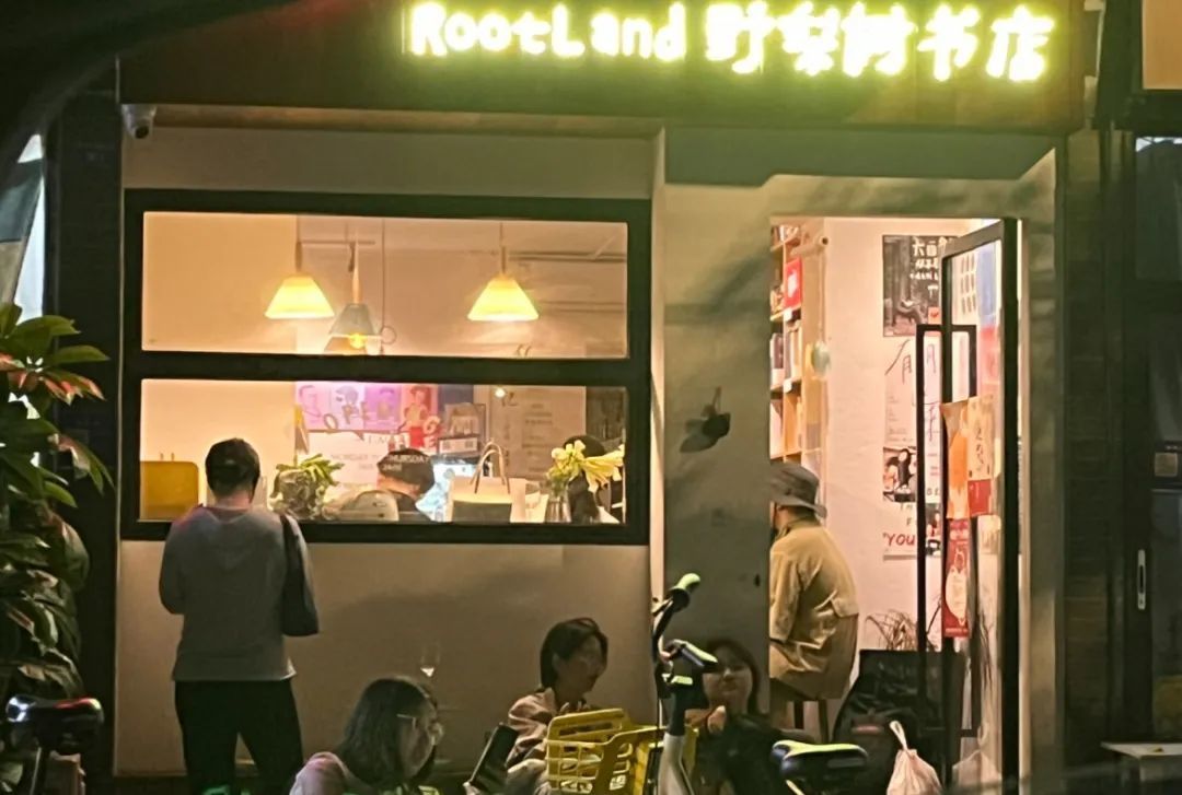 晚上九点，我离开野梨树时从街对面拍下了这张照片，来来往往的人并不清楚，小店里面藏着一个如此热烈的世界（图/阿祯 摄）