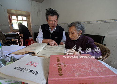 揭家堡村村民揭振漟老人（左）在查看族谱。