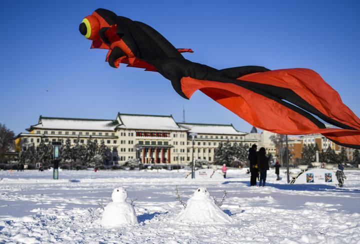 在长春市文化广场拍摄的雪地中的两个雪人。新华社记者 许畅 摄