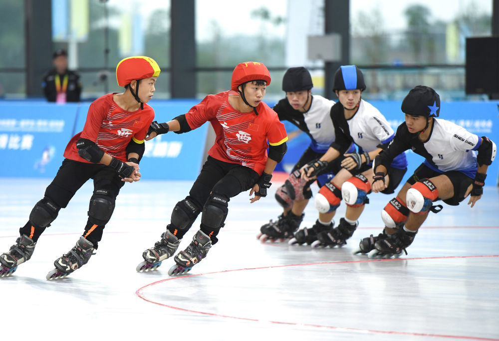 11月6日,在第一届全国学生(青年)运动会男子轮滑阻拦决赛中,南宁市队(左)以27:17战胜深圳市队,夺得冠军。新华社记者 周华 摄
