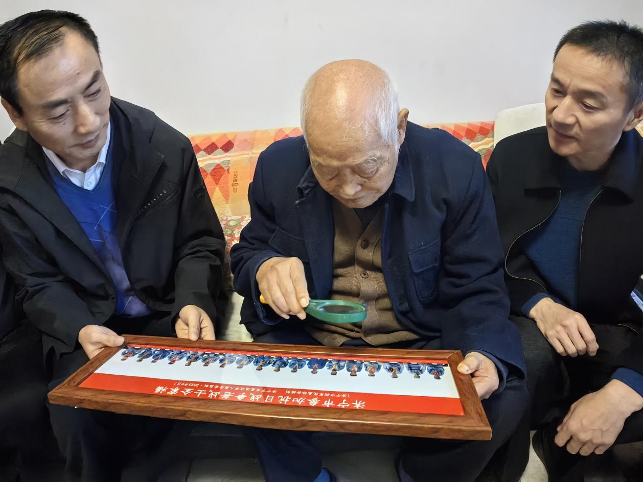 上图：济宁市退役军人事务局正县级干部、济宁市拥军优属协会会长于彦柱、微山县退役军人事务局局长李冰将抗日老兵“全家福”照片送给微山县夏镇街道抗日老兵高福俭家里。