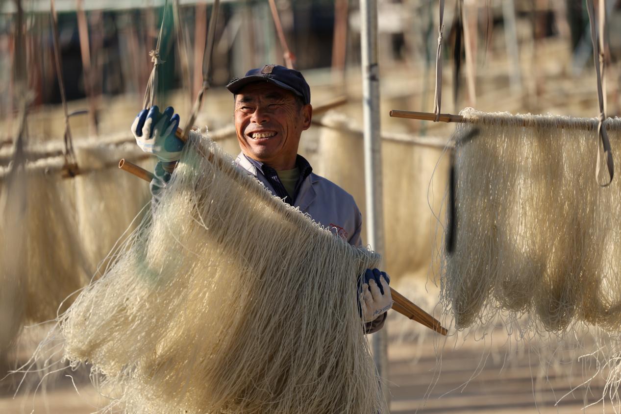 趁着阳光晴好的天气将漏出来的粉条绕成捆状挂在架子上通风晾晒空气里弥漫着红薯淀粉特有的气息也成为一道别致的风景线。宋年升 摄
